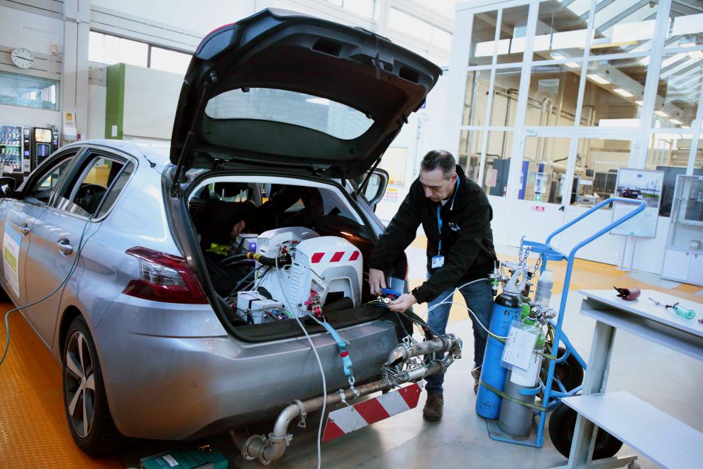 A scientist is setting up a portable emissions measurement system (PEMS) at the JRC vehicle emissions laboratory.