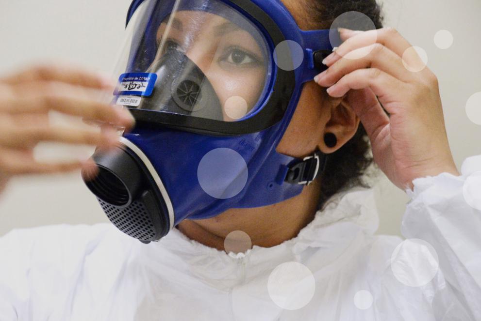 Person pulling tight straps of a breather mask protecting from toxic environment