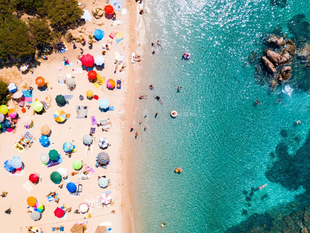 An image of a Mediterranean beach with sunbathers