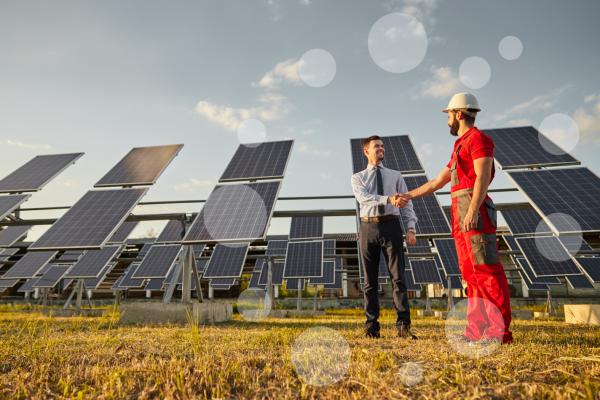 Supervisor and engineer shaking hands in solar power field