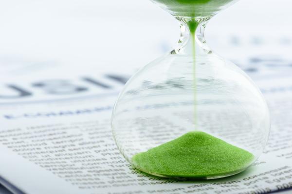 Green sand clock - hourglass timer on business report 
