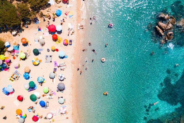 An image of a Mediterranean beach with sunbathers