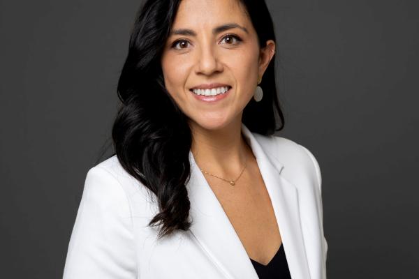 photo of a young latino woman, black hair, in a white suit