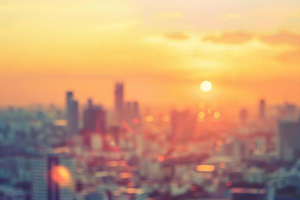 Blurred cityscape at golden hour with warm hazy sunset